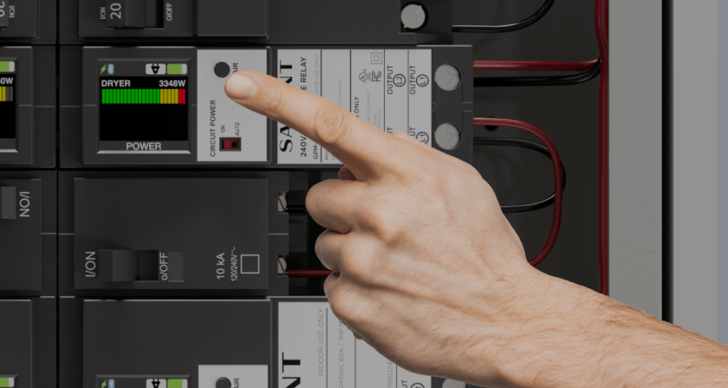 Hand pointing at a circuit breaker panel with digital displays
