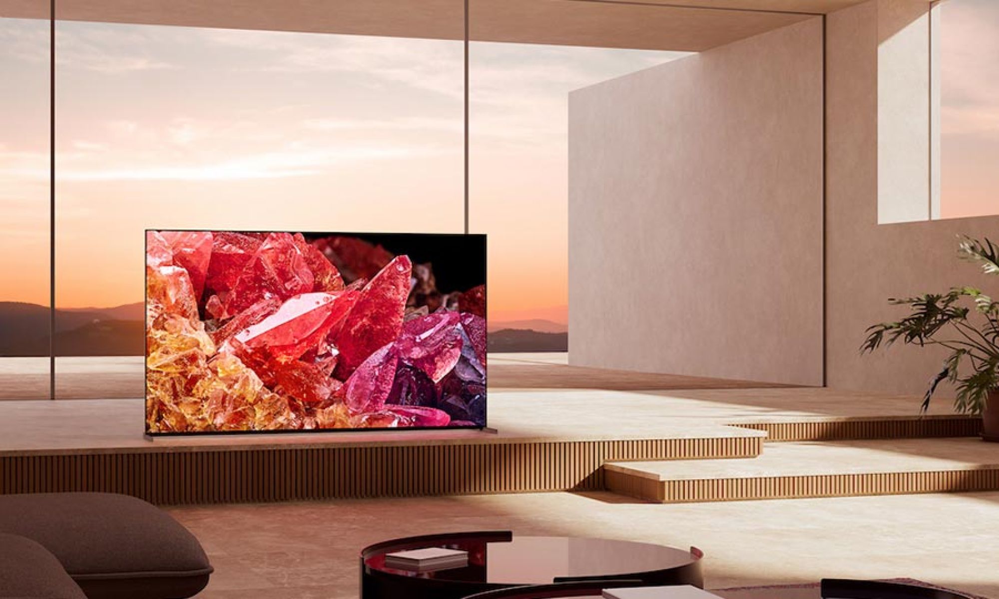 A luxurious, modern living room with a large television displaying vivid crystal imagery, overlooking a scenic sunset.