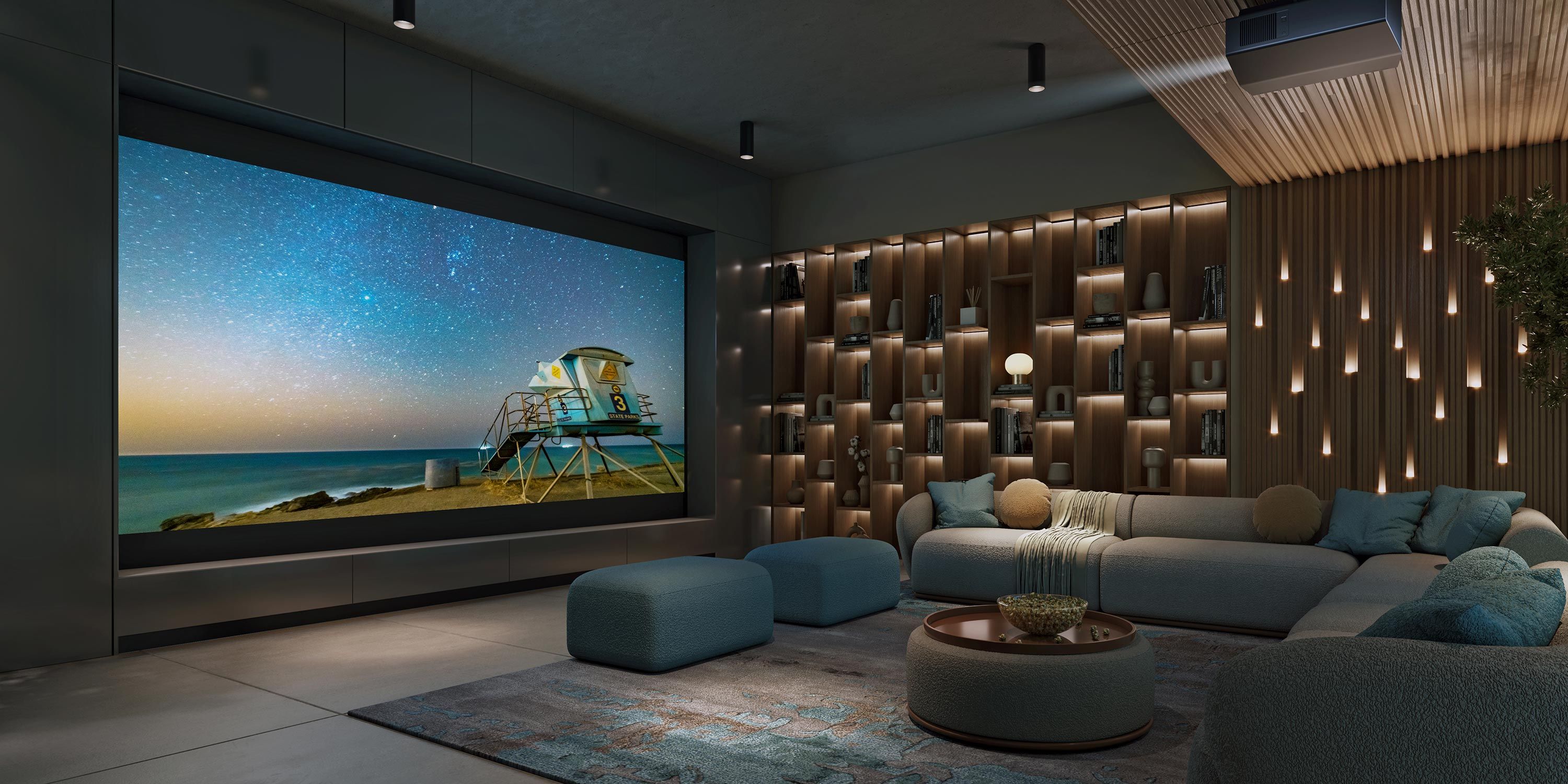 A stylish home theater featuring a large screen displaying a beach and starry sky, with plush seating and a wall with built-in shelving illuminated by ambient lighting.