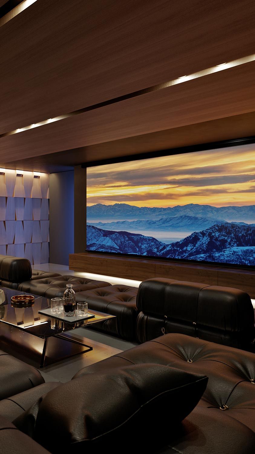 A luxurious home theater features black leather seating and a large screen displaying a snowy mountain landscape during sunset.